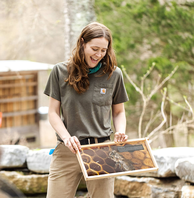 a woman holding a picture of a bee