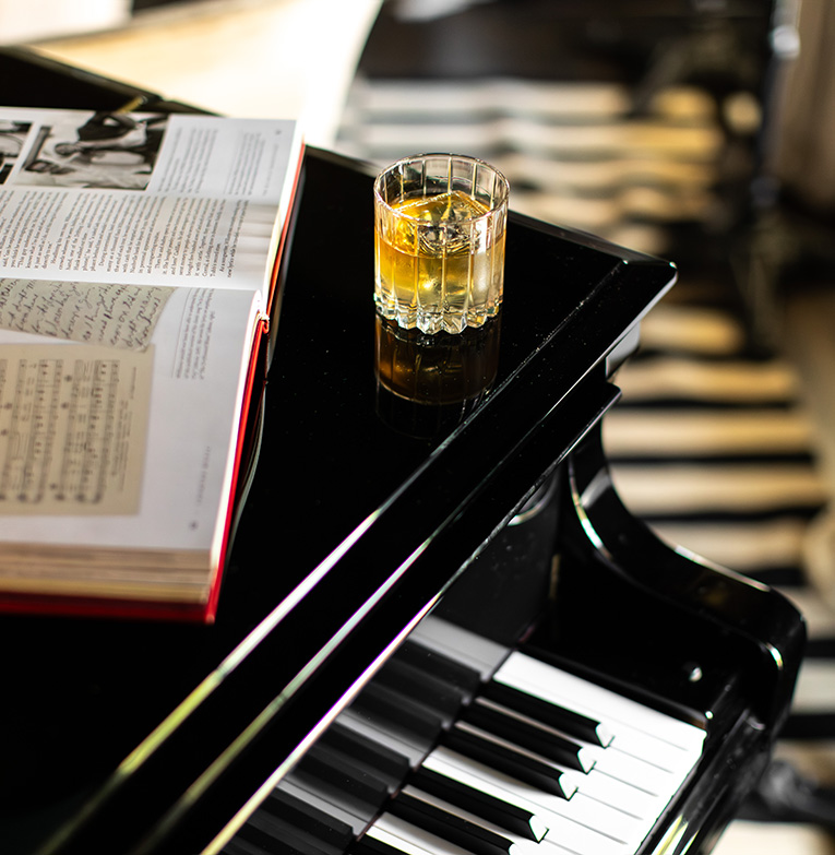 a glass of alcohol on a piano