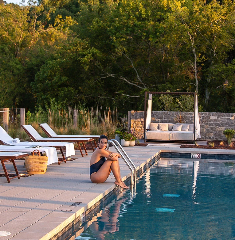 a woman sitting on a pool edge