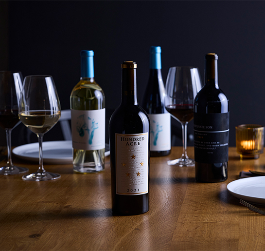 a table with wine bottles and glasses