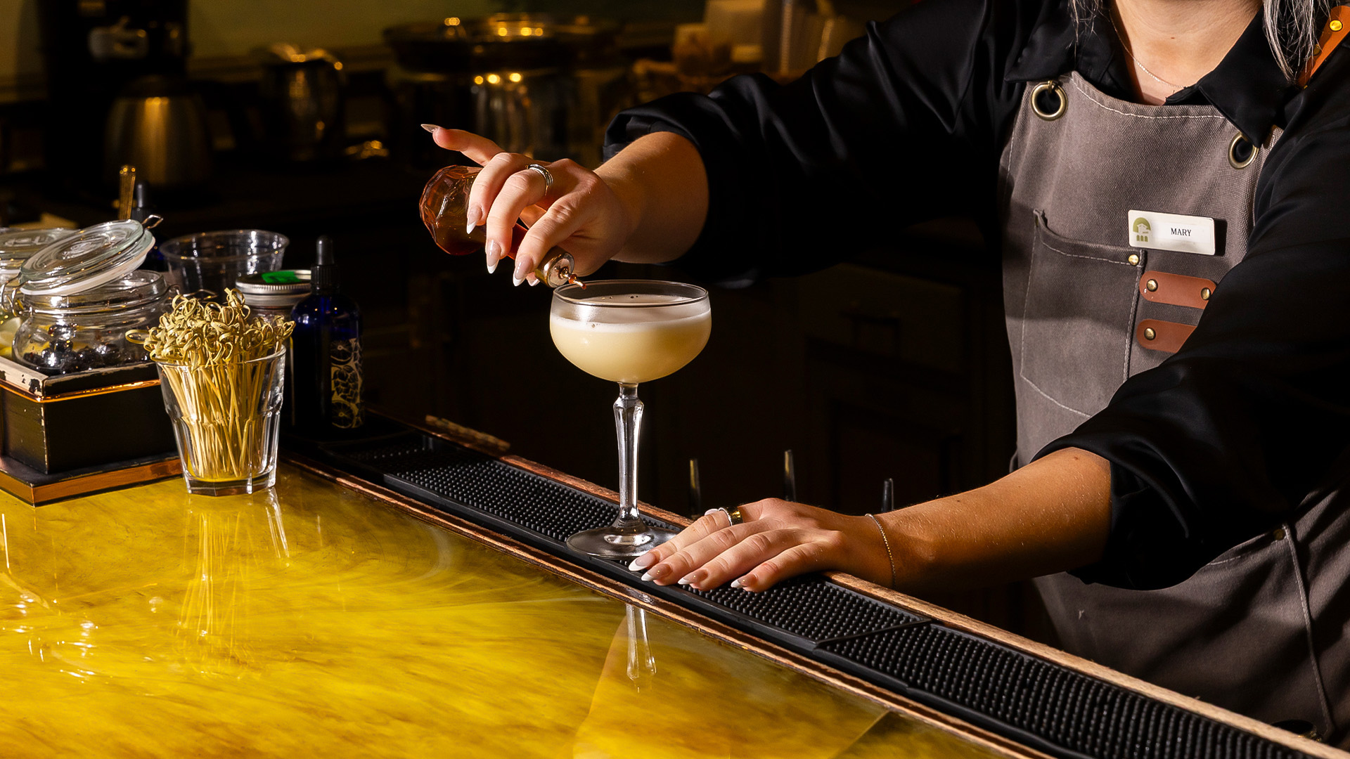a person pouring a drink into a glass