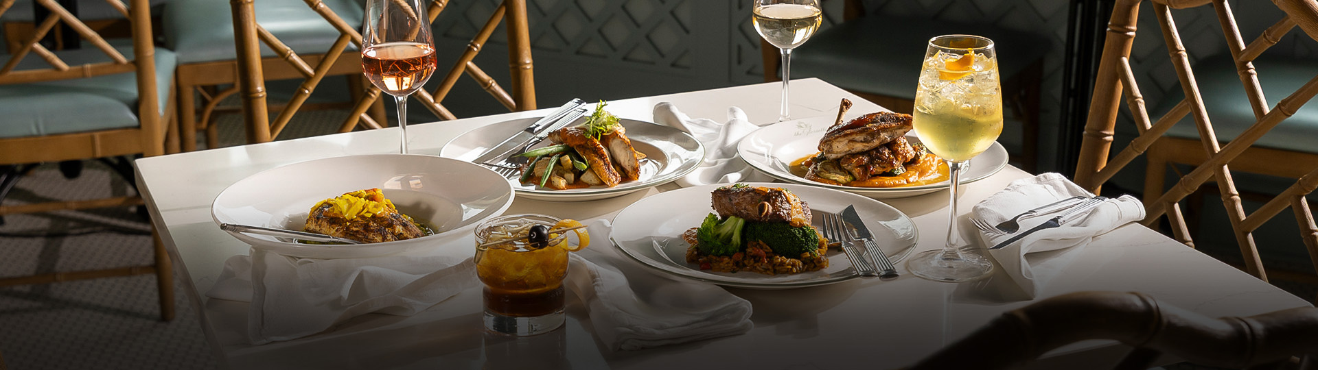 a table with plates of food and glasses of wine