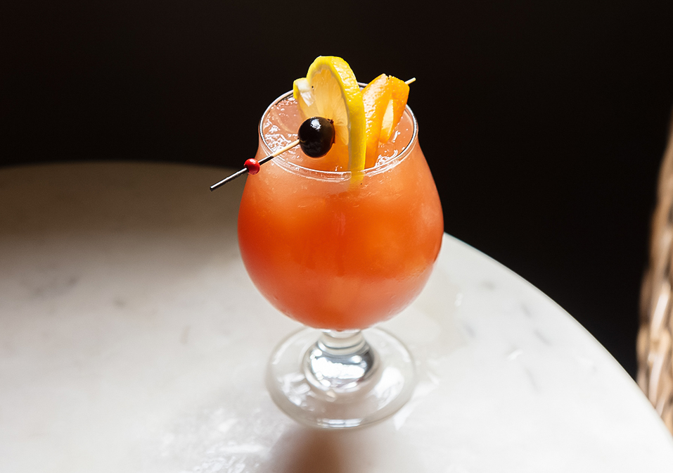 a glass with a drink and a stick on it