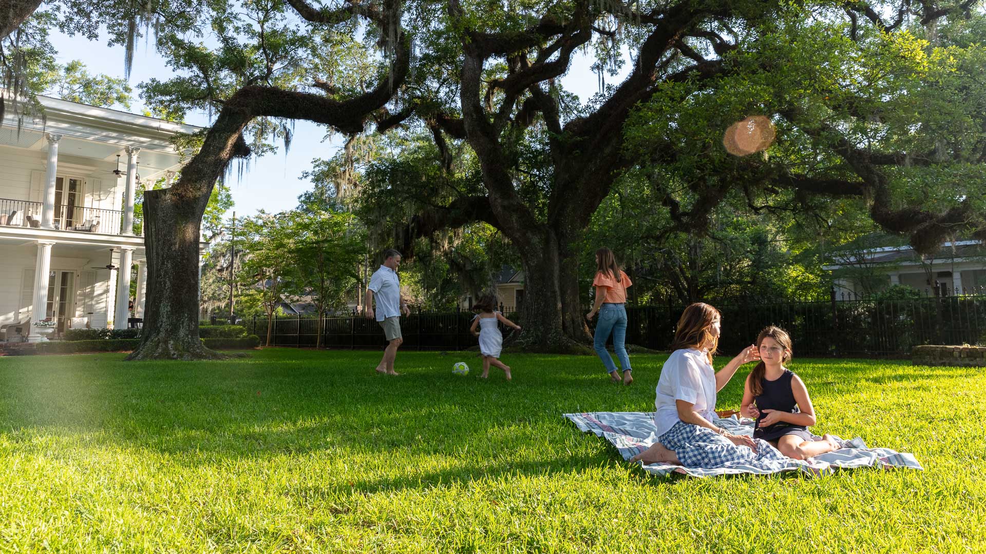 a group of people on a blanket in a park