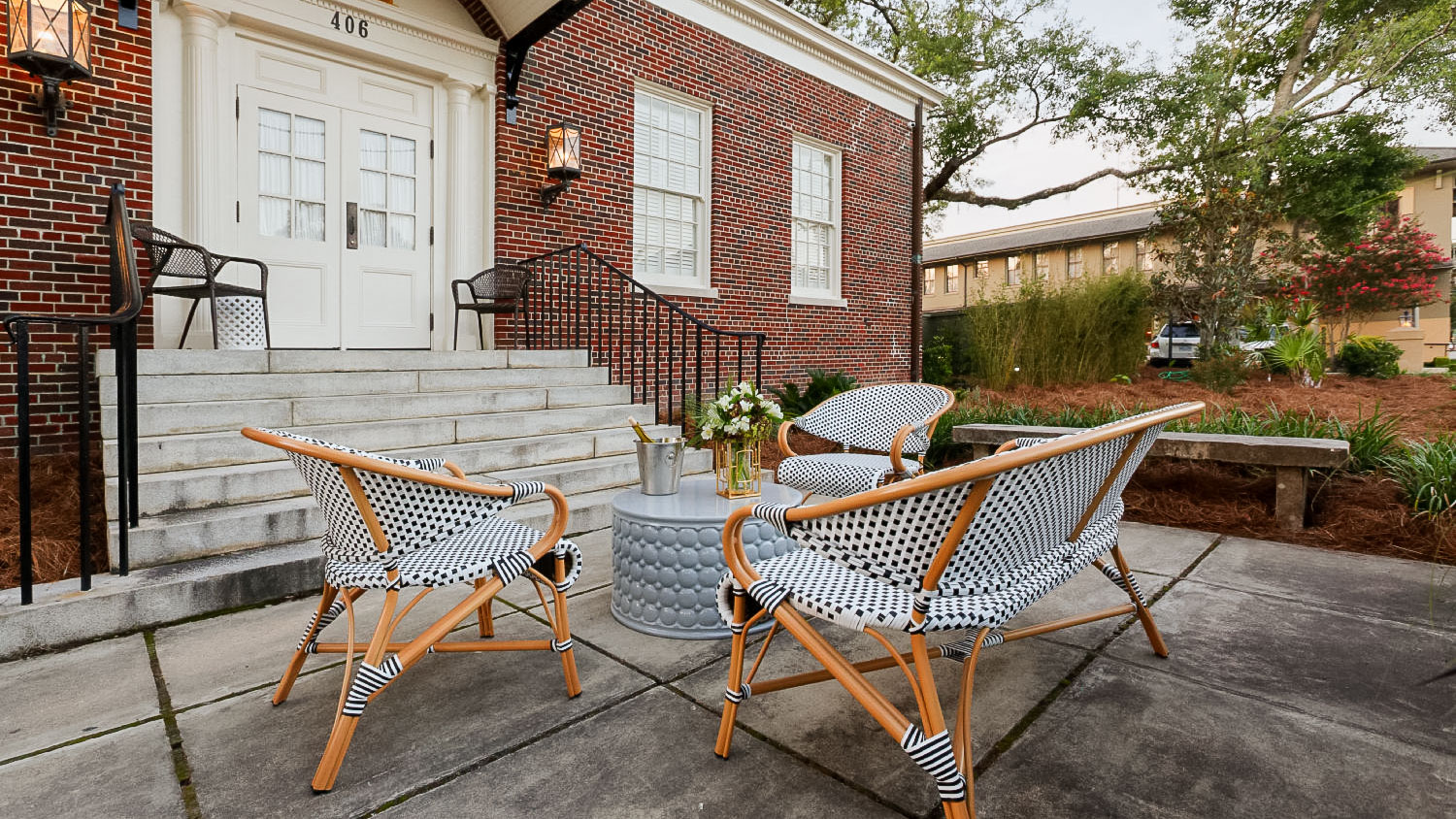 a patio with chairs and a table in front of a brick building