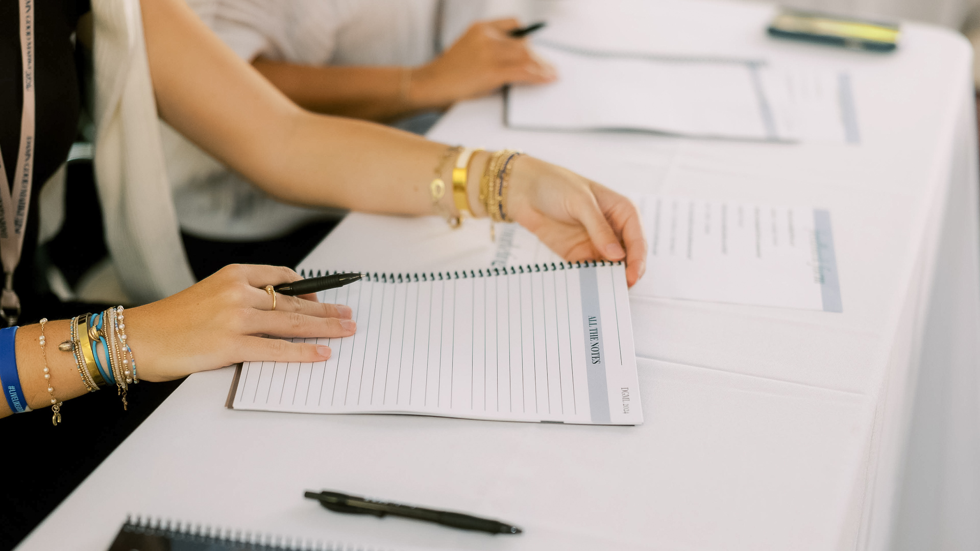a person holding a pen in a notebook