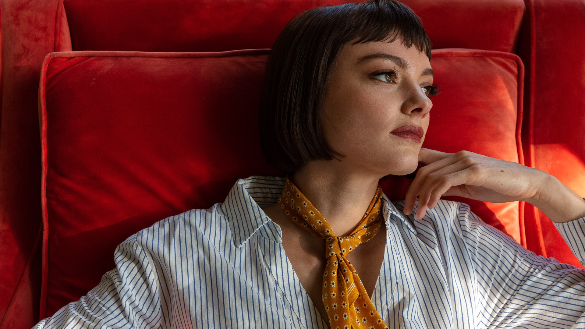 a woman lying on a red couch