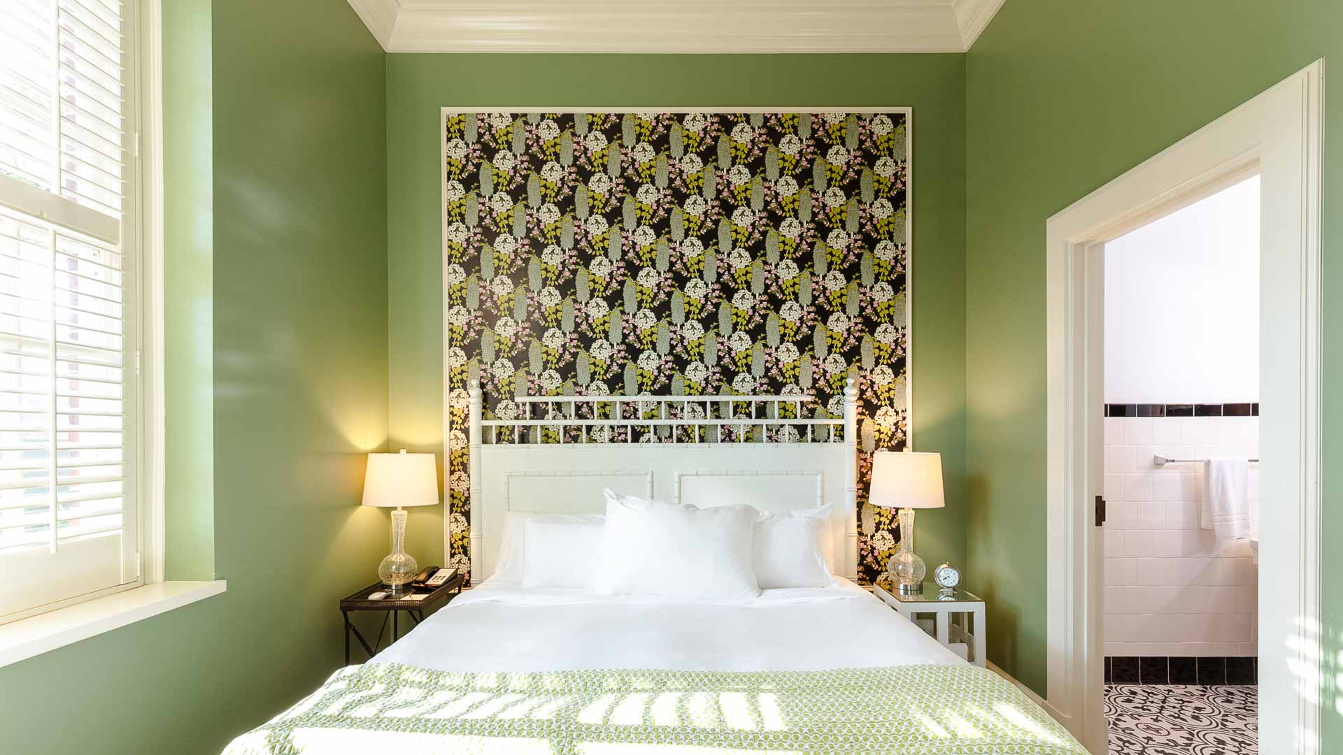 a bed with a floral wallpaper