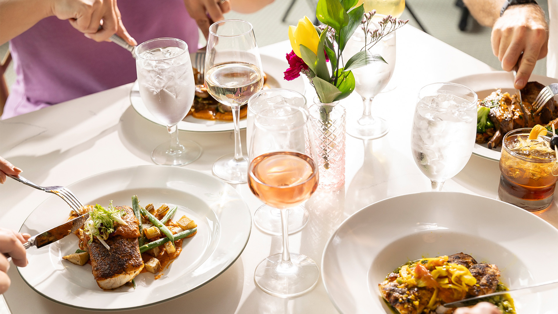 a table with plates of food and glasses of wine