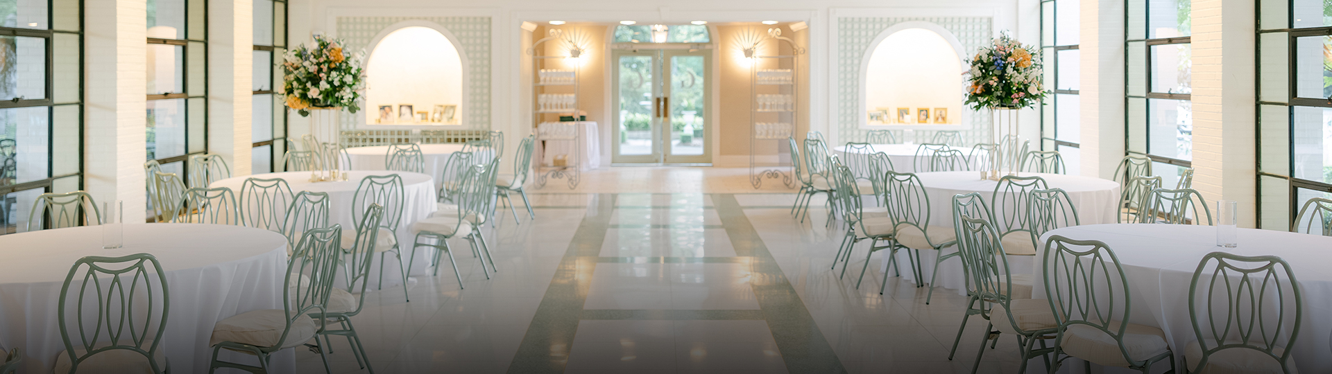 a room with white chairs and tables