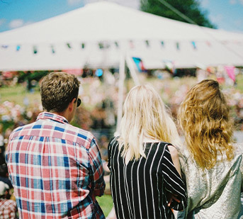 people looking on to a festival and white tent set up