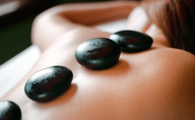a person's back with black stones on them