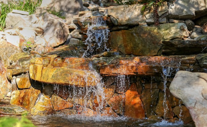 a waterfall with water falling from rocks