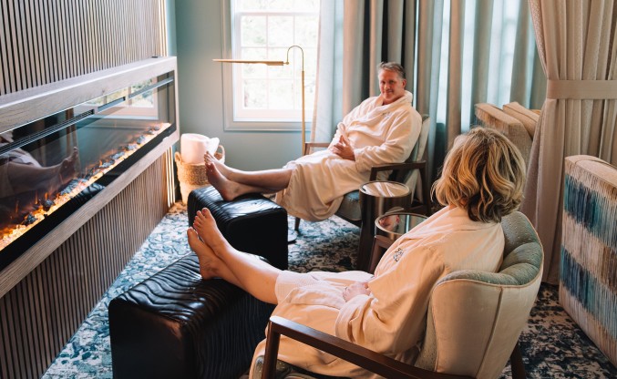 a woman in a white robe sitting in a chair with a man in a chair