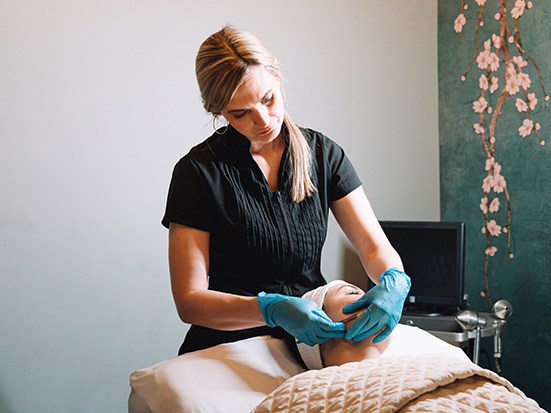 a woman wearing gloves and scrubbing a woman's head