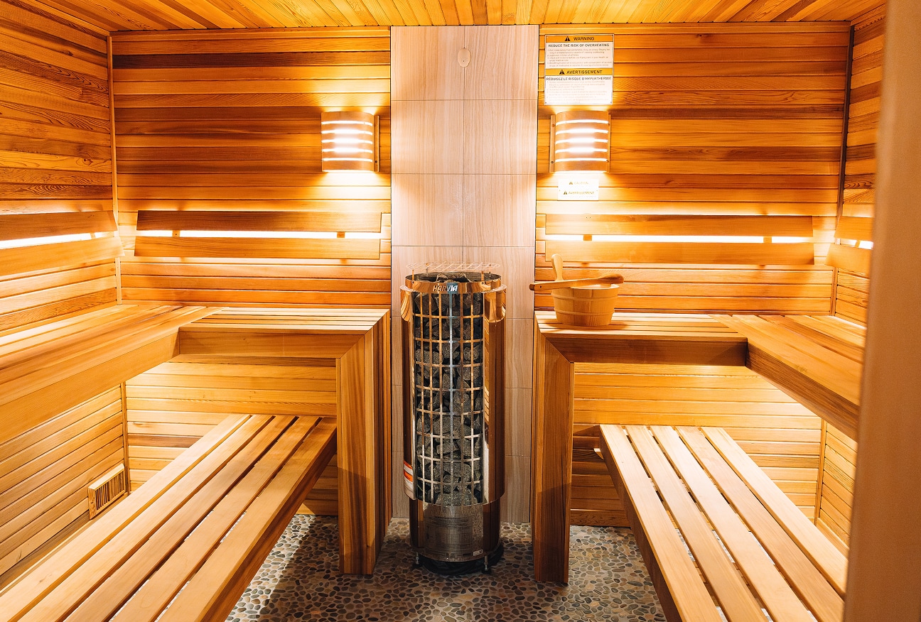 a wooden sauna with benches and a bucket