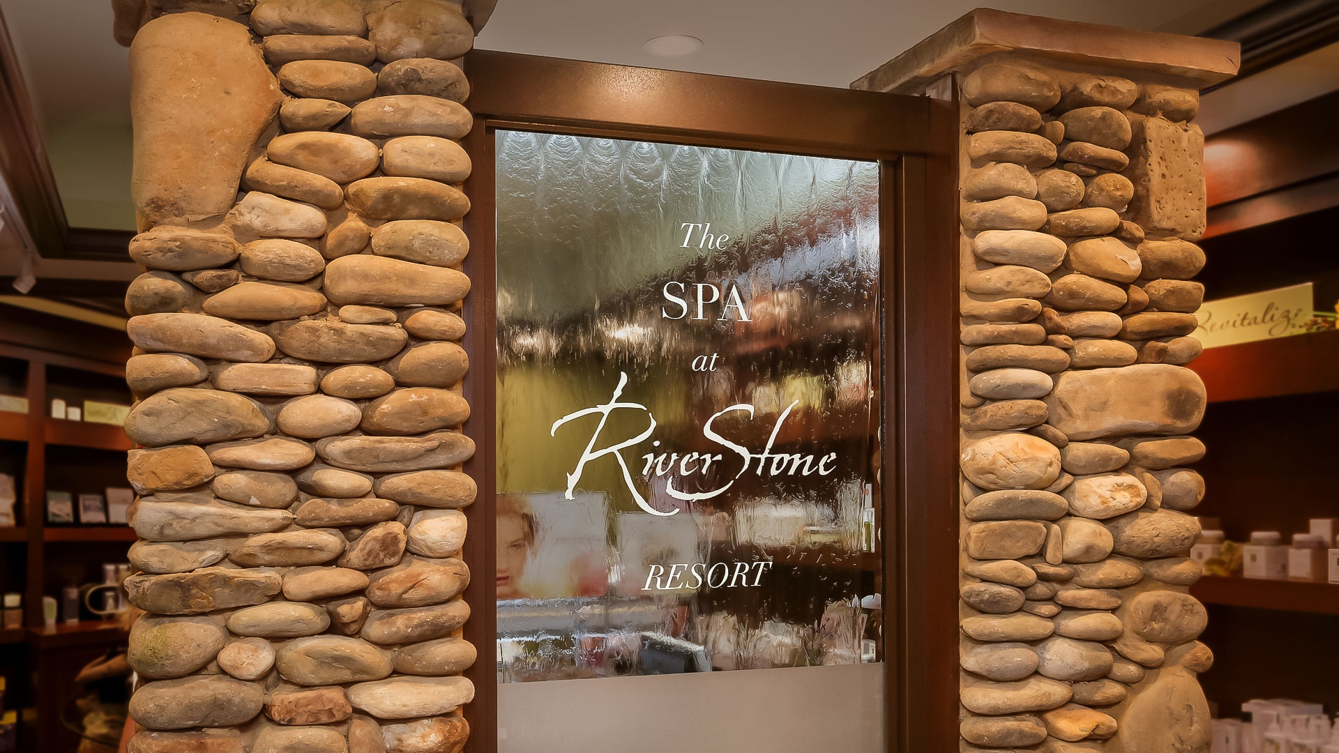 a door with a glass door and a stone column