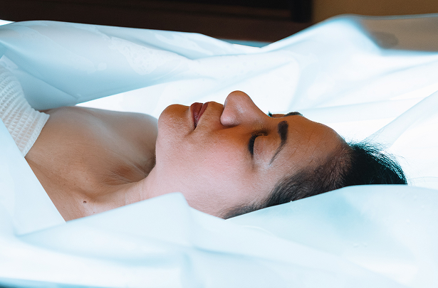 a woman lying down with her eyes closed