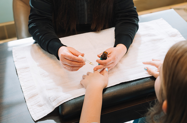 a person applying nail polish on a woman's hand