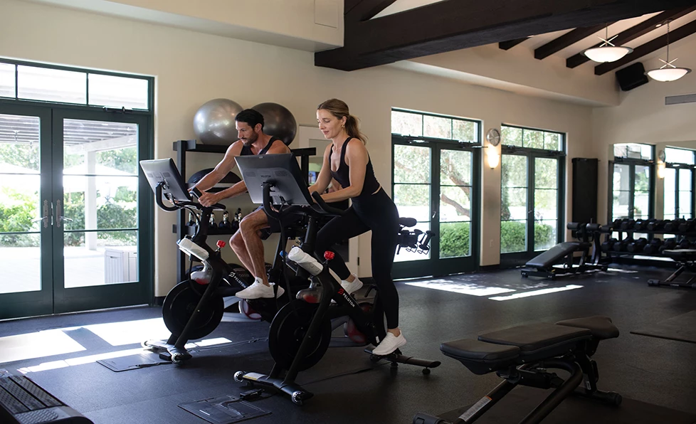 a man and woman on exercise bikes