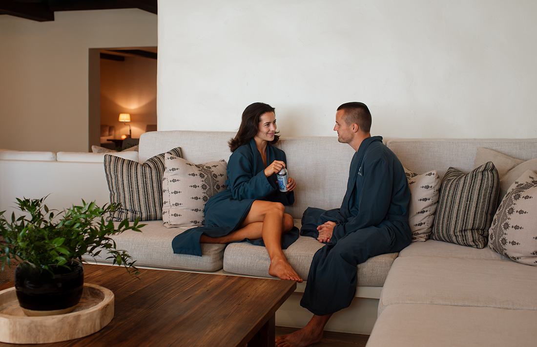 a man and woman in bathrobes sitting on a couch