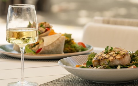 a plate of food and a glass of wine