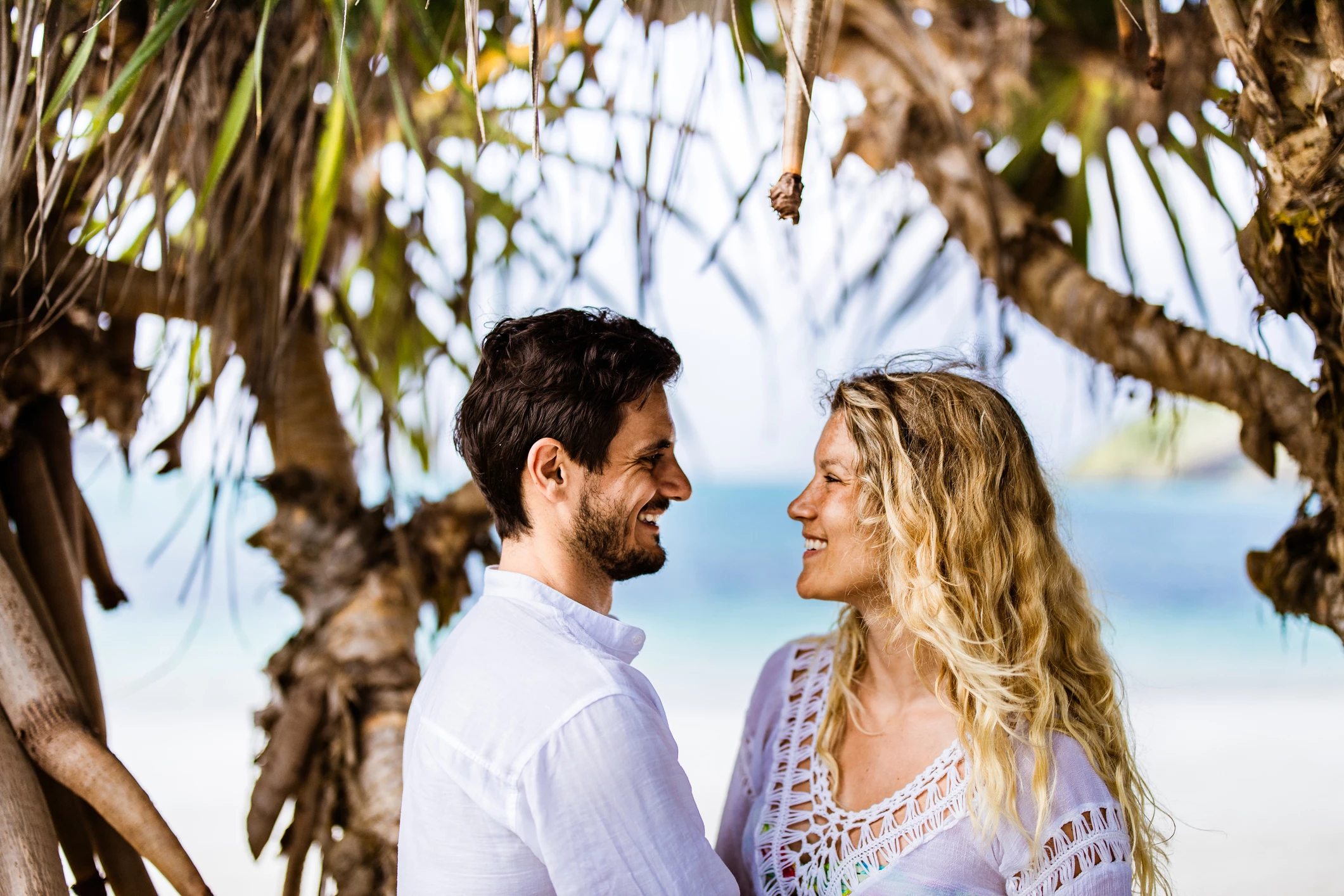 a man and woman standing under a tree