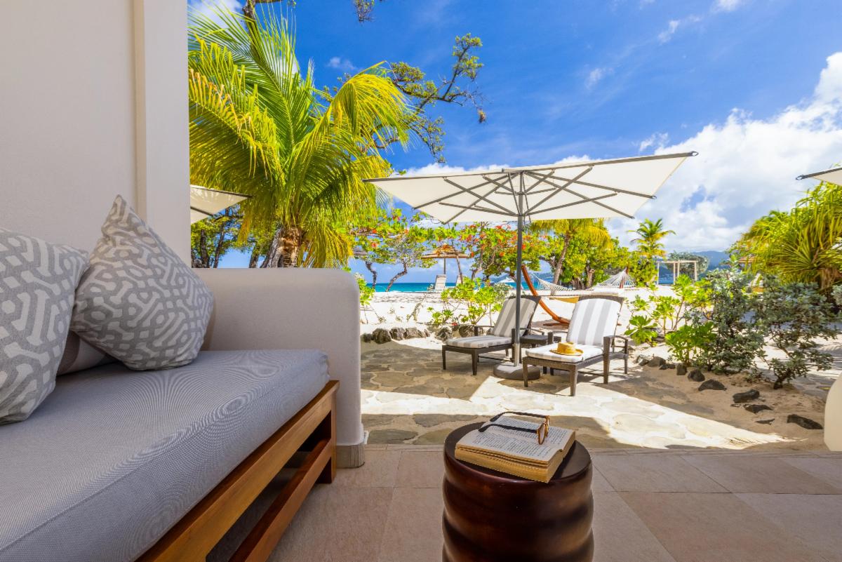 a patio with a chair and umbrella on the beach
