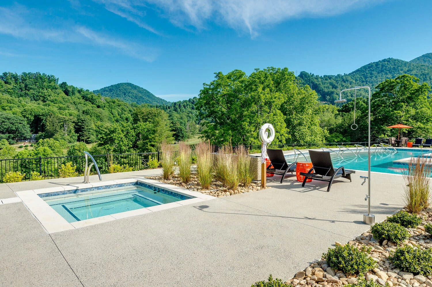 a pool and chairs by a building