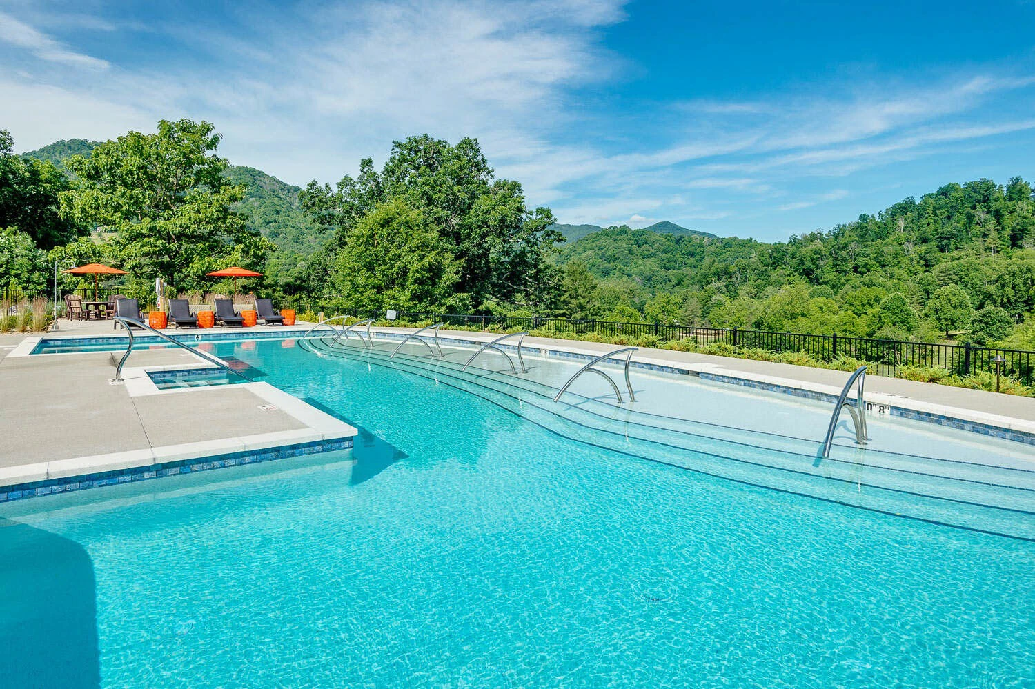 a swimming pool with chairs and trees