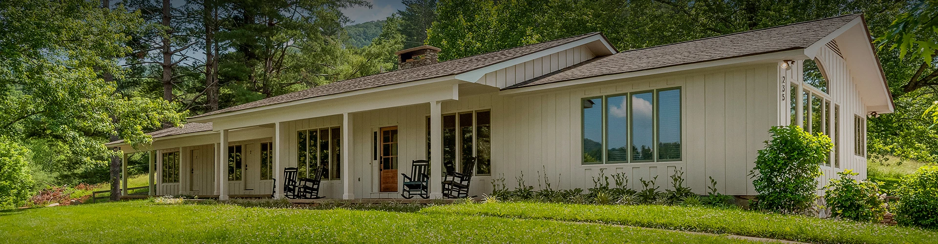 a white house with a lawn and chairs with Millard Fillmore House in the background