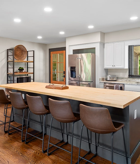 a kitchen with a large island and chairs