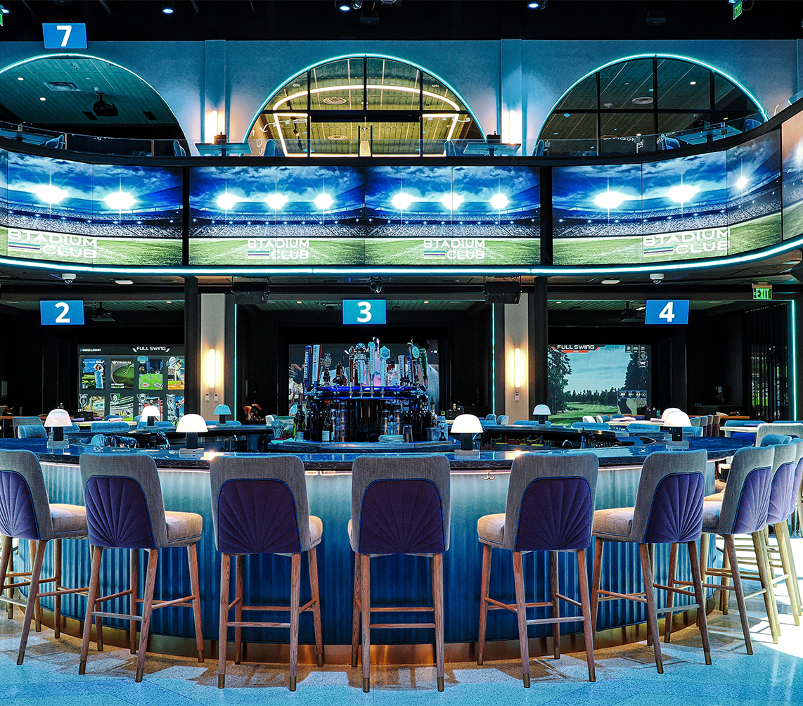 a bar with chairs and a television screen