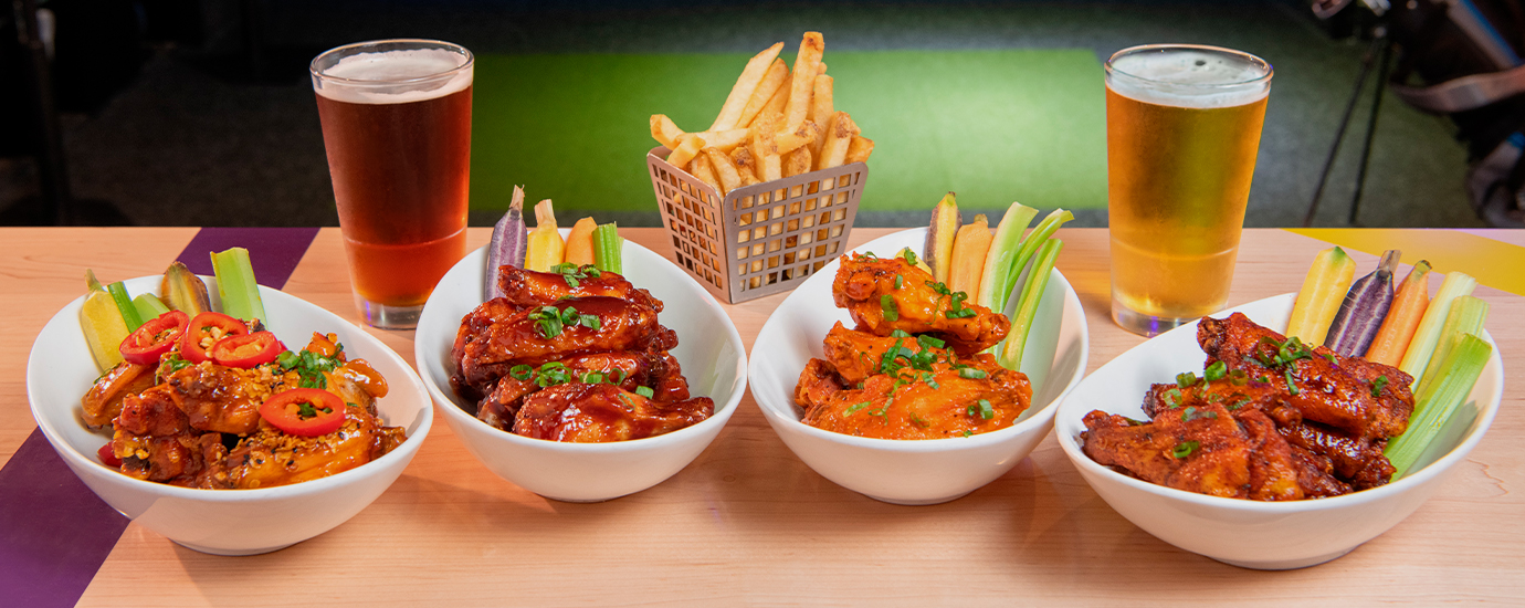 a couple of bowls of chicken wings and fries