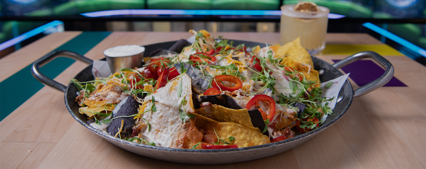 a plate of nachos with cheese and vegetables