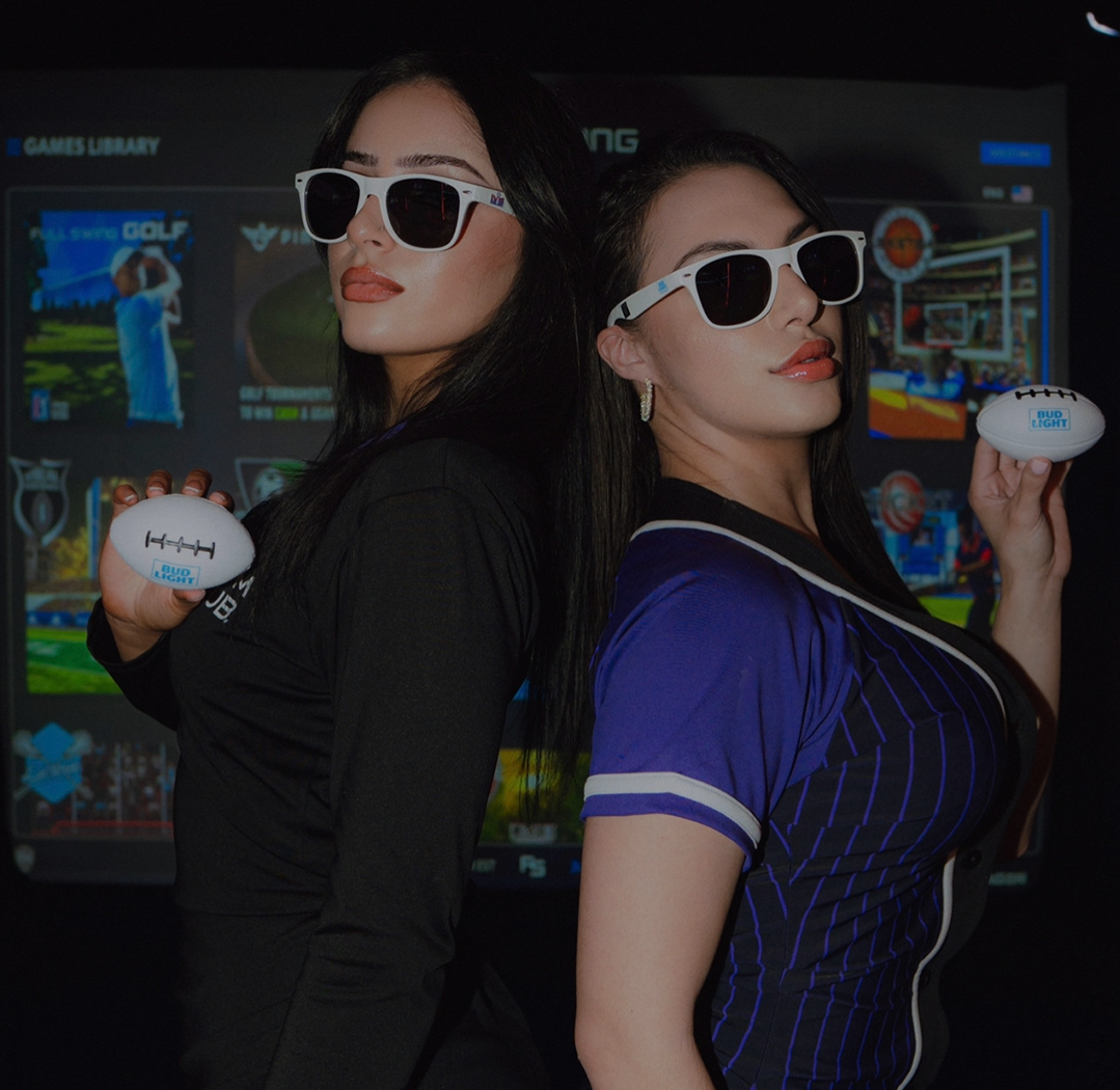 two women wearing sunglasses and holding footballs