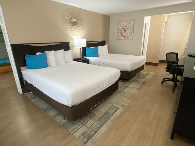 a room with two beds and a chair