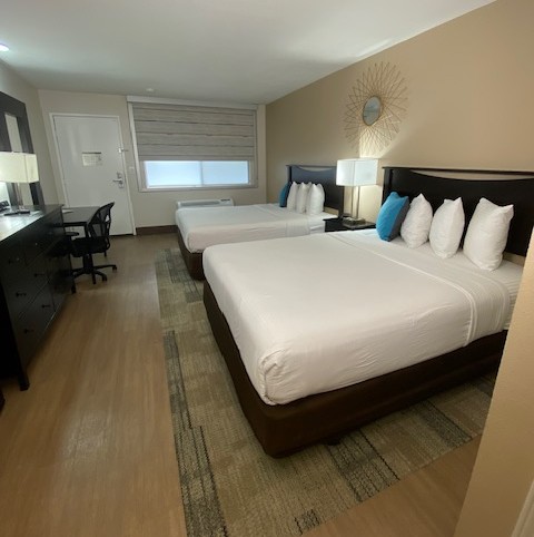 a room with two beds and a desk