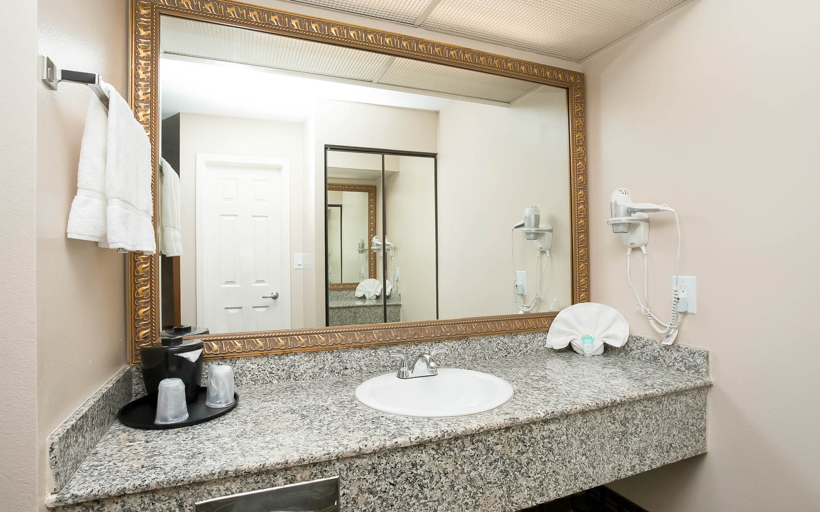 vanity with gray marble sink and gold frame