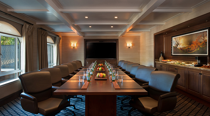 a long conference room with chairs and a table with fruit on it