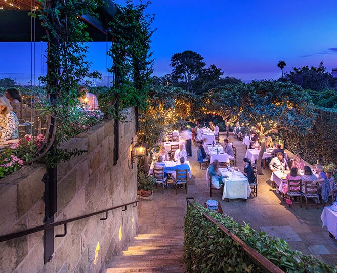 aerial view of people dining at tables outside during the sunset