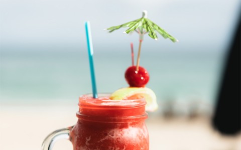 a glass mug with a drink and umbrella on top