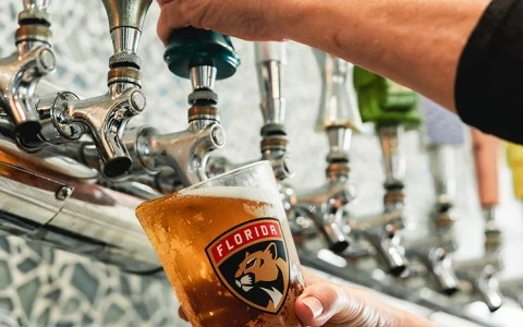 a person pouring beer from a tap