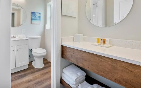 a bathroom with a round mirror and a sink