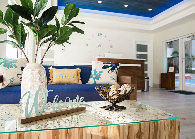 a living room with a blue couch and a welcome sign