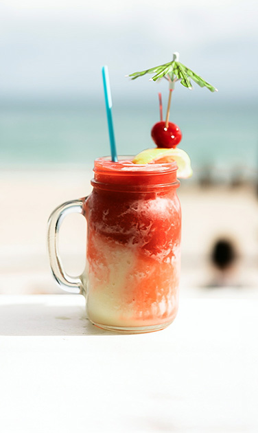 a glass mug with a drink and straw
