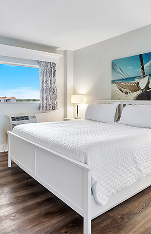 a bed with a lamp and a picture of a ship