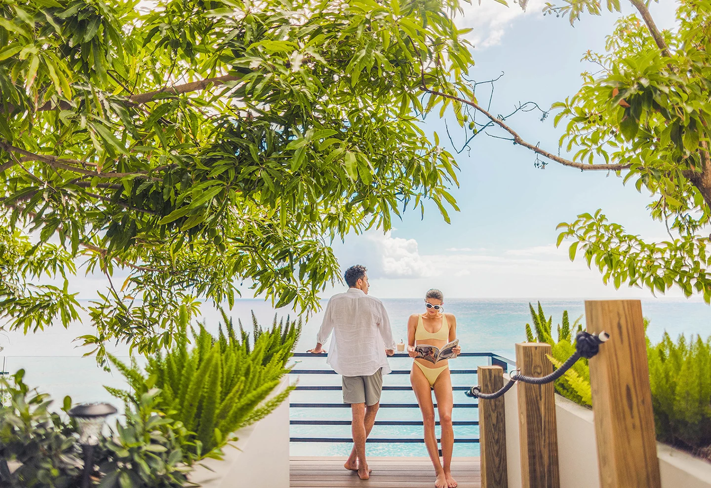 a man and woman standing on a deck by a body of water