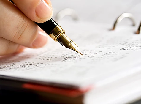 woman writing in an agenda 