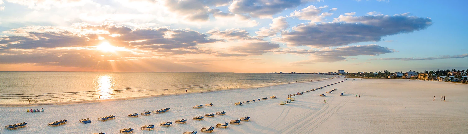 sunrise over a white sand beach and the ocean 